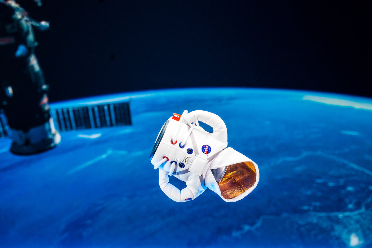 Puffin Drinkwear The Spacesuit floating in space keeping a drink cold