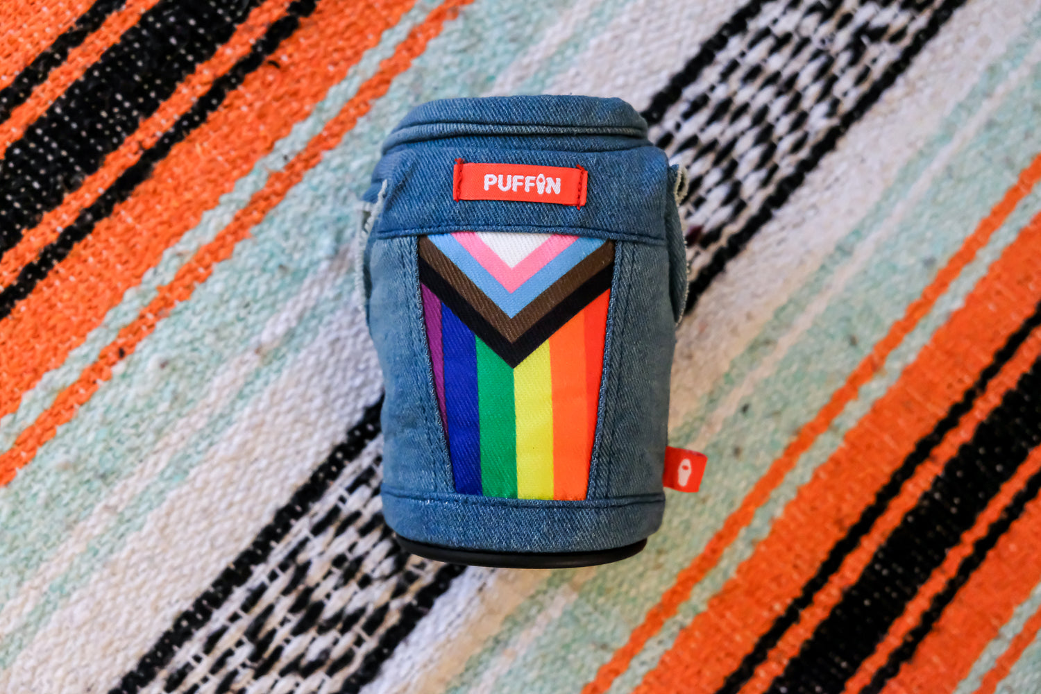 The Pride Vest - Puffin Drinkwear drink sleeves - laying on a colorful blanket